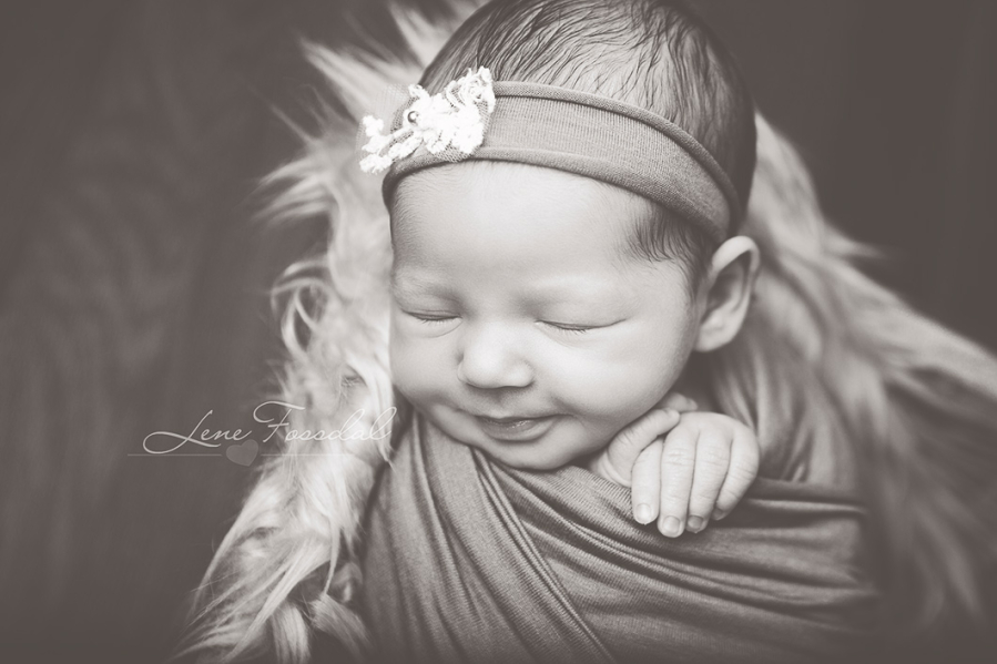 Close-up der en av modellbabyene smiler.