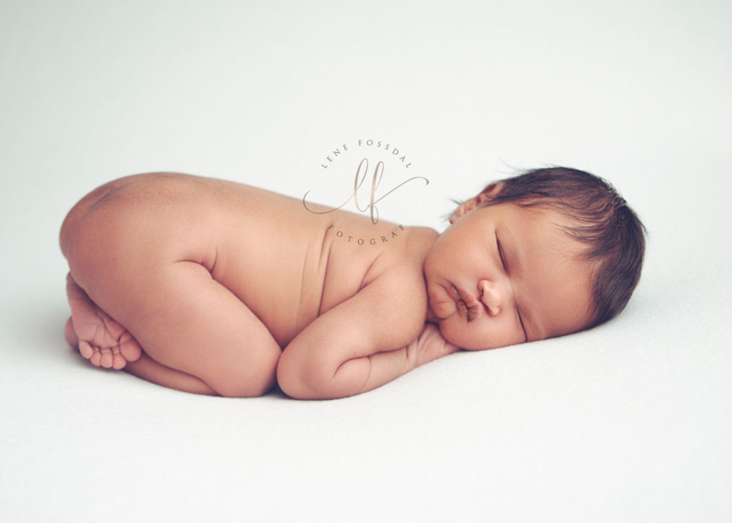 Nyfødt baby på hvit bakgrunn.