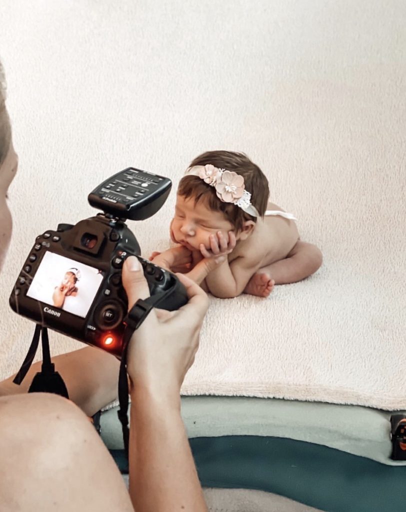 Behind the scenes bilde av Lene som fotografere en nyfødt.