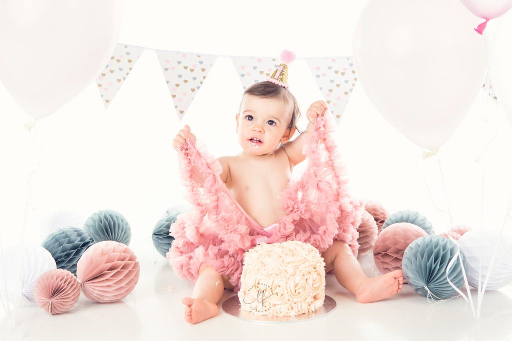 En jente på 1 år med cake og tutuskjørt. Kaken smashes som en del av fotograferingen.