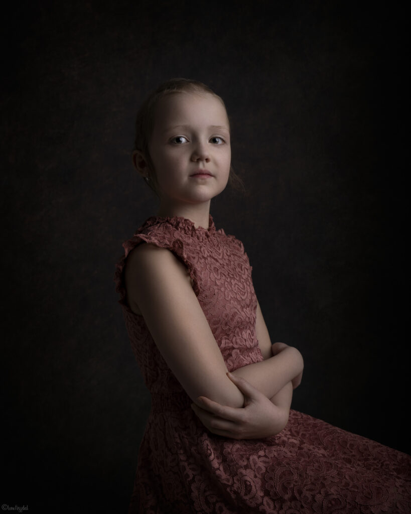 Linea har alopecia. Hun sitter rett i ryggen og ser i kamera.